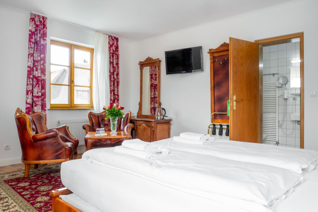 Zimmer 203 – Bett, Sitzecke und Bad