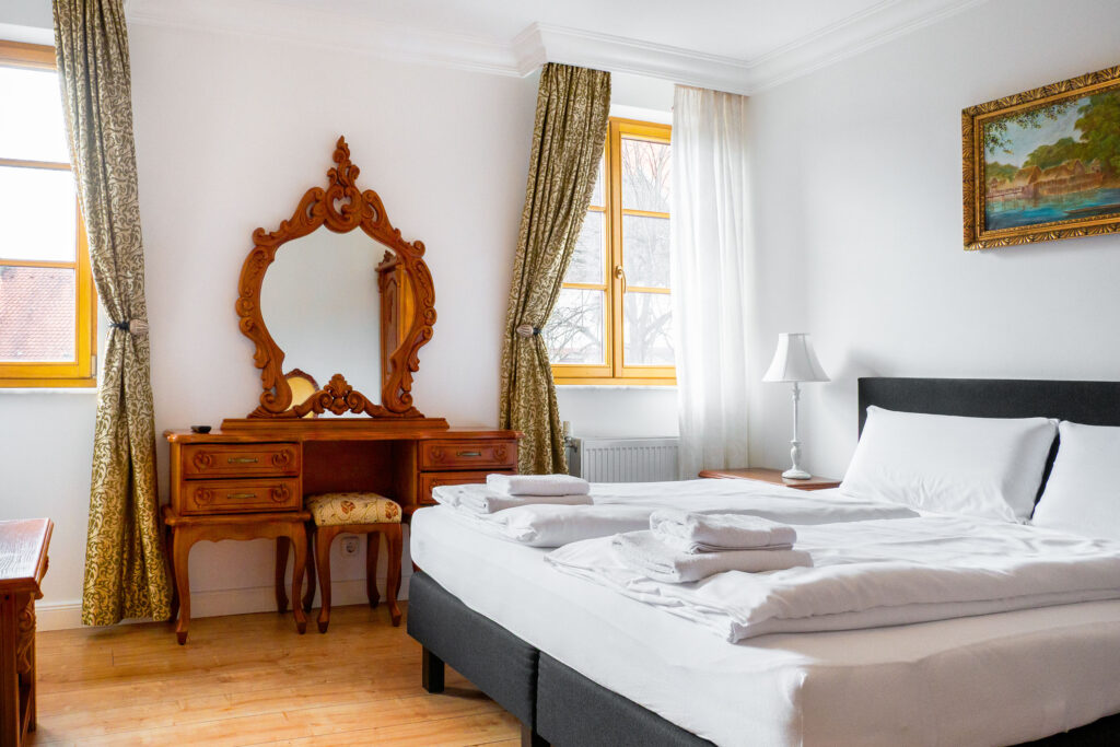 Zimmer 205 – Bett, Fenster und Spiegel