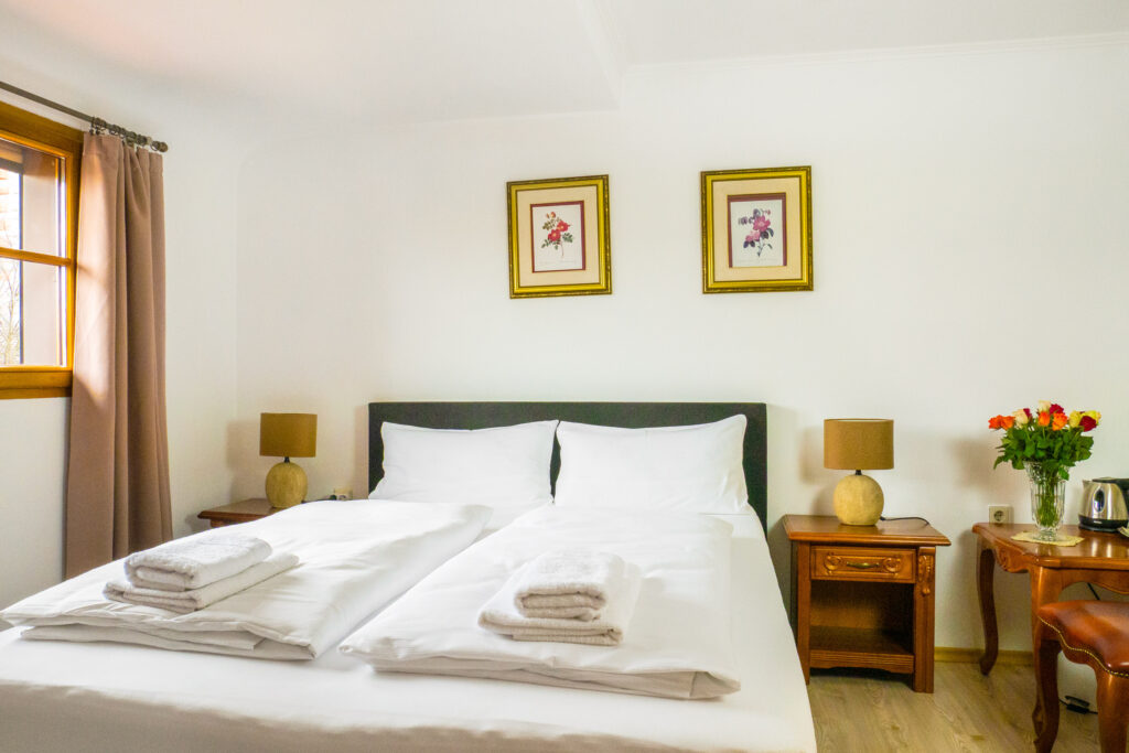 Zimmer 303 – Bett, Fenster und Blumen