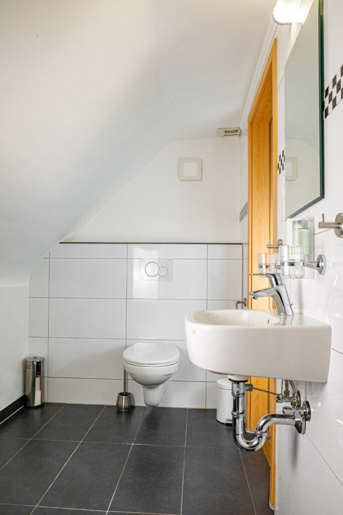 Zimmer 304 – Badezimmer mit Waschbecken und Toilette