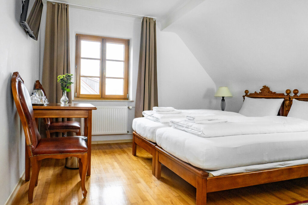 Zimmer 302 – Bett, Fenster und Tisch