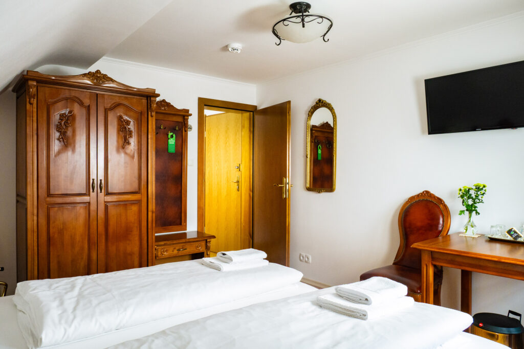 Zimmer 302 – Bett, Schrank, Tür und TV