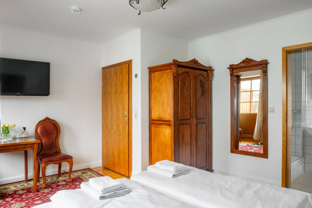 Zimmer 202 – Bett, Tisch, Tür und Bad