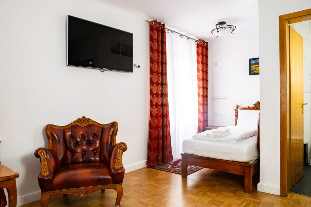 Zimmer 102 – Bett, TV, Fenster und Bad