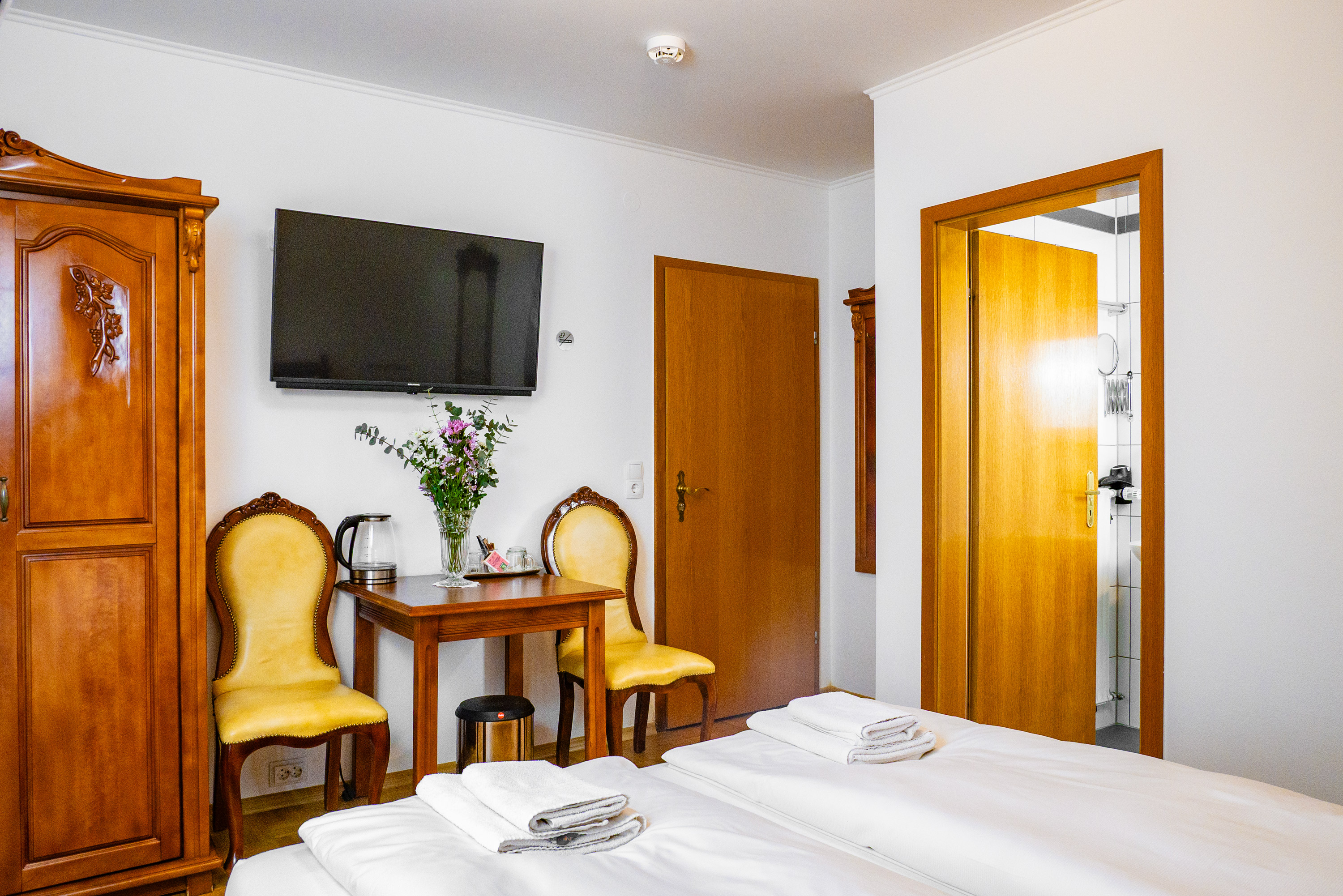 Zimmer 101 – Innenansicht mit Tisch, Tür und Bad